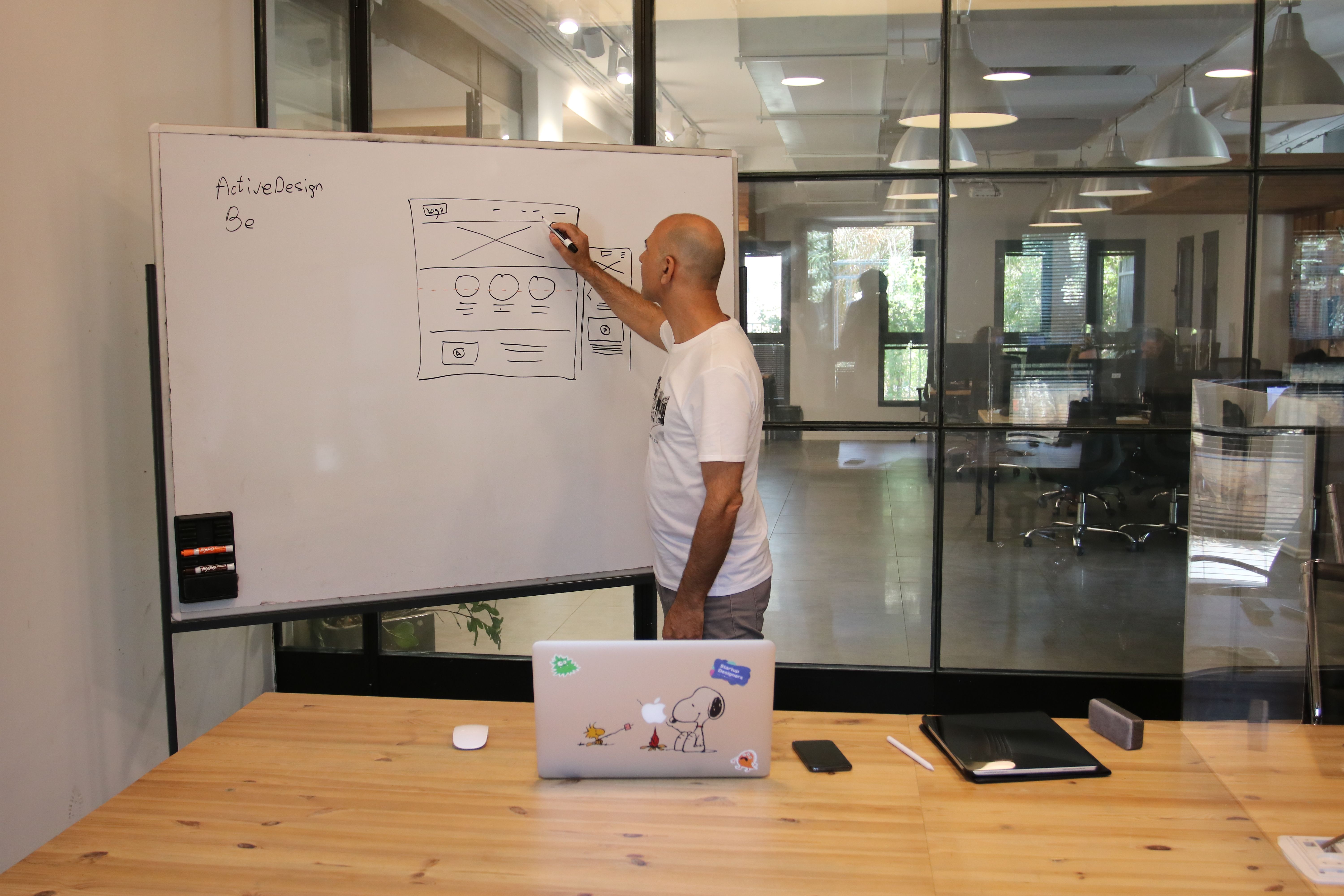 A designer mapping an interface on a whiteboard